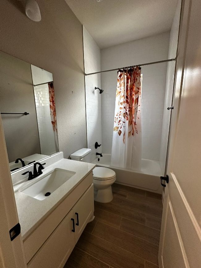 Full bathroom with wood finished floors, vanity, and shower / bathtub combination with curtain | Image 16