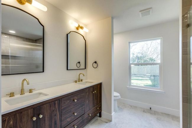 Bathroom with toilet, double vanity, visible vents, and a sink | Image 7