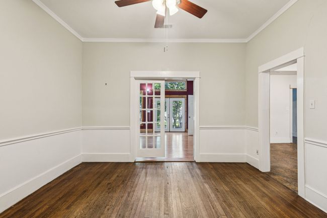 Empty room with hardwood / wood-style floors, ceiling fan, ornamental molding, french doors, and baseboards | Image 7