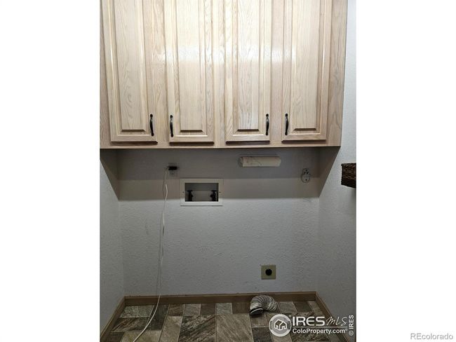 Main level laundry is located between the kitchen and garage door | Image 13