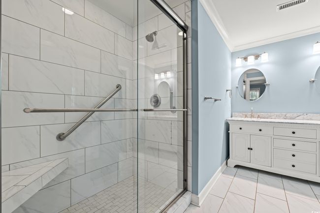 Bathroom with crown molding, vanity, a stall shower, and marble look tiles | Image 14