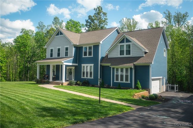 View of front facade with a garage, aphalt driveway, covered porch, a front yard, and a shingled roof | Image 41