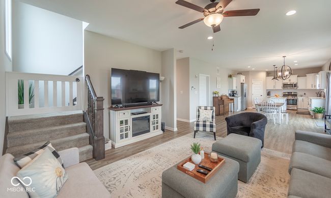 Living area featuring recessed lighting, light wood-type flooring, stairs, and ceiling fan with notable chandelier | Image 5