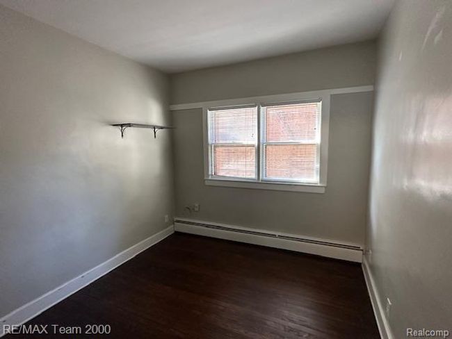 Unfurnished room featuring baseboard heating and dark wood-style flooring | Image 12