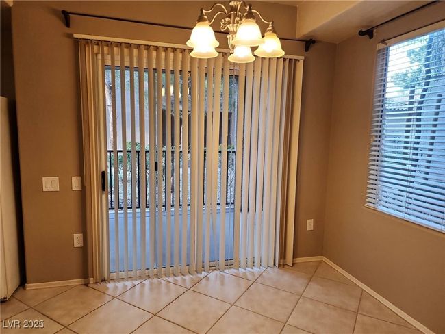 Tiled empty room with a chandelier and baseboards | Image 16