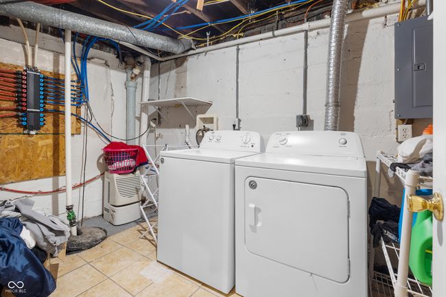 clothes washing area with washing machine and clothes dryer, electric panel, laundry area, and light tile patterned flooring | Image 24