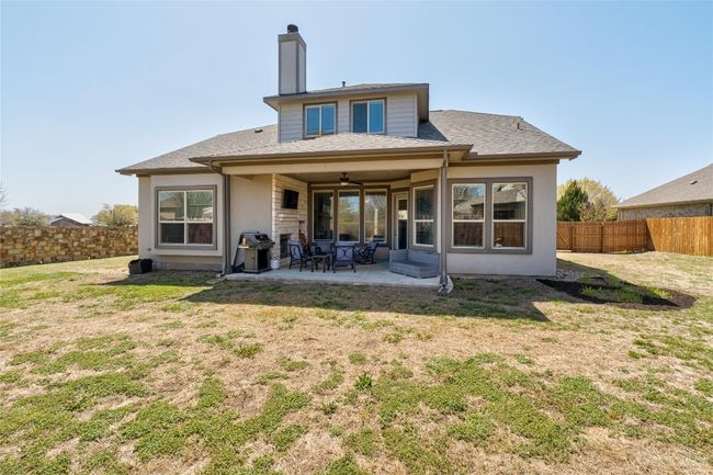 Back of house featuring a ceiling fan, a fenced backyard, a yard, and a patio area | Image 30