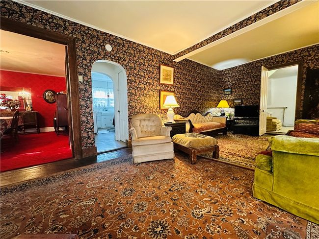 Unit 1 - Living room - The arched doorway leads to the kitchen. The open door to the right connects to unit 2. | Image 7
