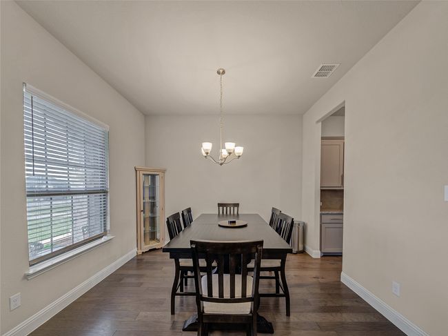 Dining room featuring a chandelier and dark wood-style floors | Image 7