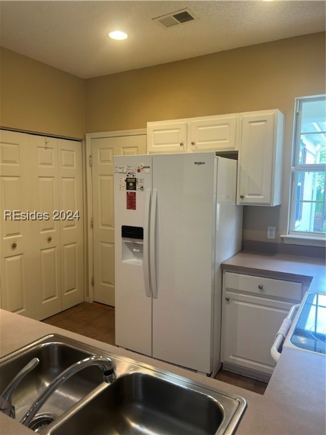 Kitchen with white cabinets, sink, stainless steel range, white fridge with ice dispenser, and a textured ceiling | Image 14
