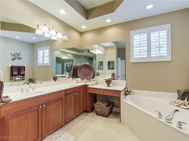 Bathroom with a wealth of natural light, a washtub, dual sinks, and large vanity | Image 19