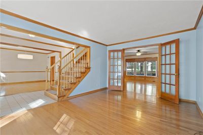 Unfurnished living room featuring hardwood / wood-style flooring, crown molding, and french doors | Image 3