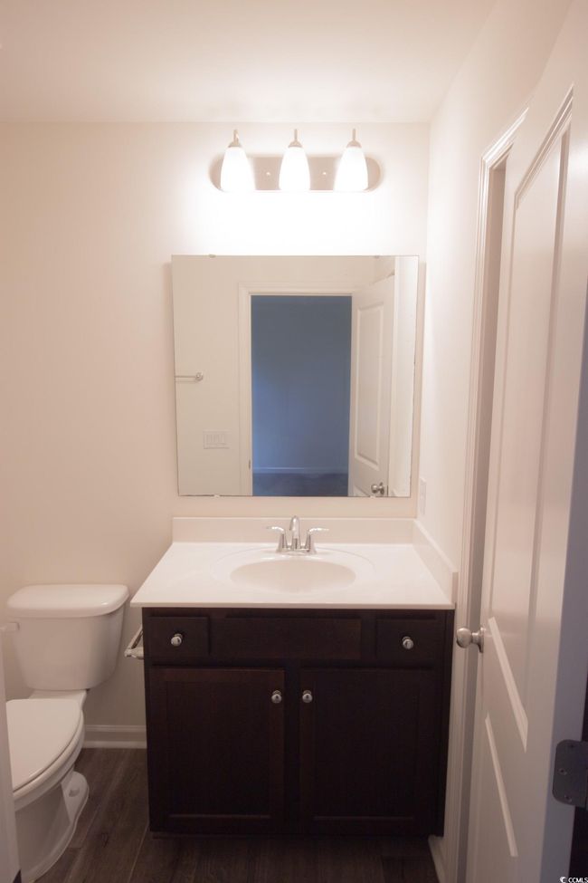 Bathroom featuring vanity, wood finished floors, toilet, and baseboards | Image 11