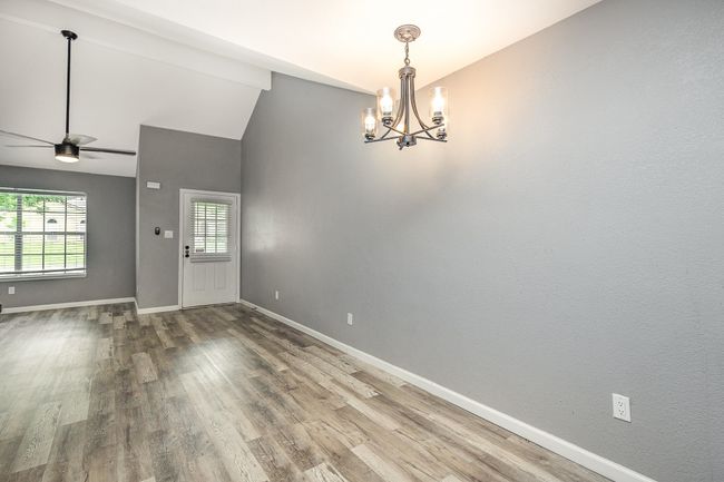 Entrance foyer featuring a chandelier, wood finished floors, baseboards, and lofted ceiling | Image 10