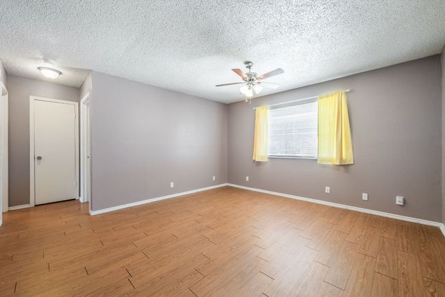 Unfurnished room with a ceiling fan, light wood-style floors, and a textured ceiling | Image 7