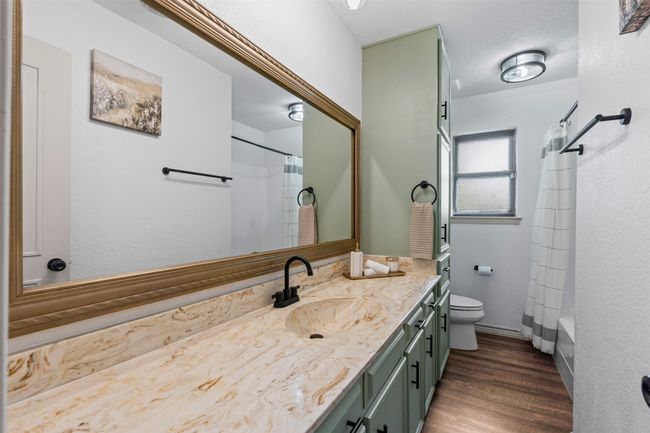 Full bathroom featuring vanity, wood finished floors, and shower / bath combo with shower curtain | Image 22