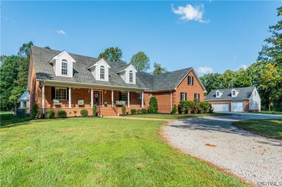 Cape cod home with central AC, a front yard, a garage, and a porch | Image 1