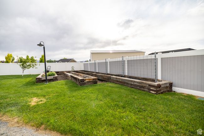 Fenced backyard featuring a vegetable garden | Image 74