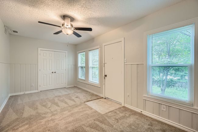 Entryway featuring light carpet, a textured ceiling, ceiling fan, and a decorative wall | Image 16