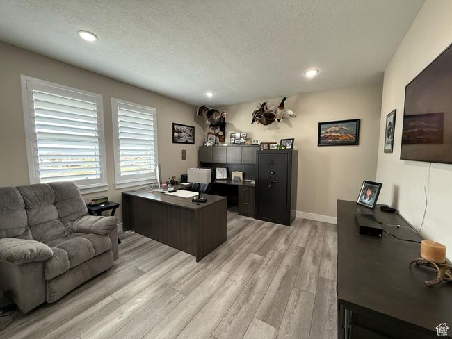 Office space with baseboards, a textured ceiling, recessed lighting, and light wood-type flooring | Image 19