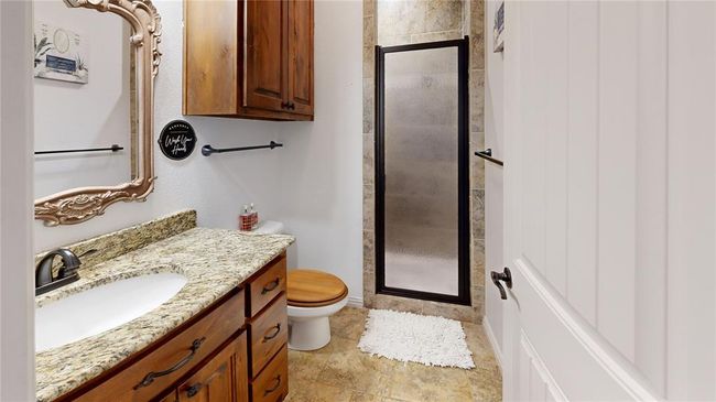 Bathroom featuring vanity, toilet, and a stall shower | Image 39