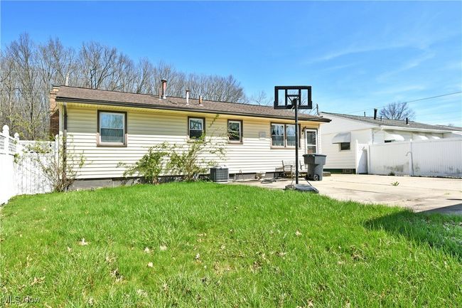 Rear view of house featuring a yard, central AC unit, a patio, and fence | Image 7