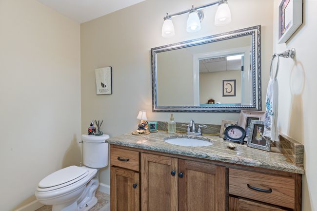 Half Bath in Basement has Granite Countertop Custom Vanity and Tile Floor | Image 40