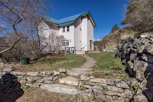 View of side of property with a lawn, a deck, and metal roof | Image 78