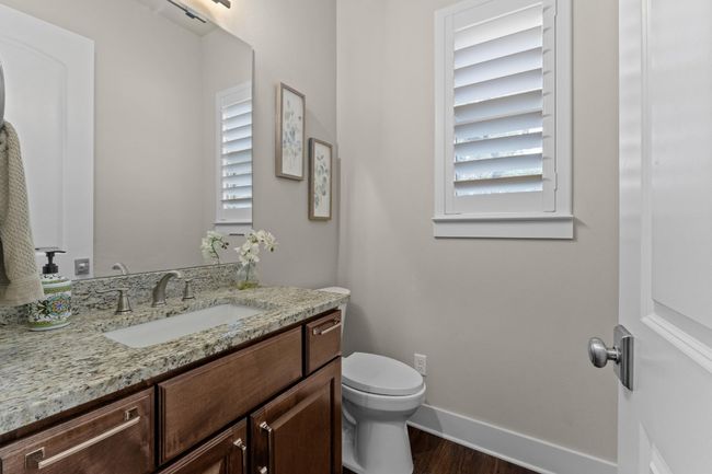 Half bathroom featuring toilet, baseboards, a healthy amount of sunlight, and wood finished floors | Image 24