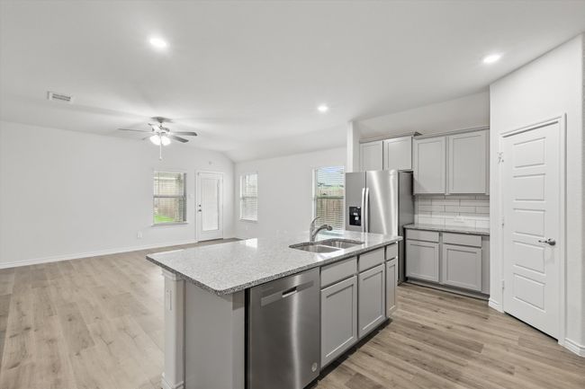 Kitchen with stainless steel appliances, gray cabinets, a ceiling fan, light wood-style flooring, and recessed lighting | Image 12
