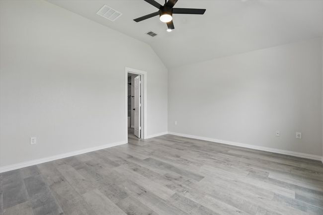 Unfurnished room with a ceiling fan, vaulted ceiling, wood finished floors, and baseboards | Image 21