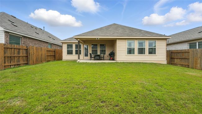 Rear view of house featuring a patio, a fenced backyard, and a shingled roof | Image 37
