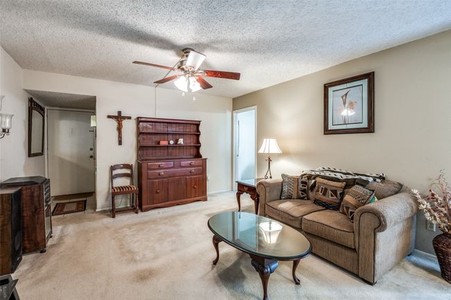Living area featuring light colored carpet, a textured ceiling, and ceiling fan | Image 5