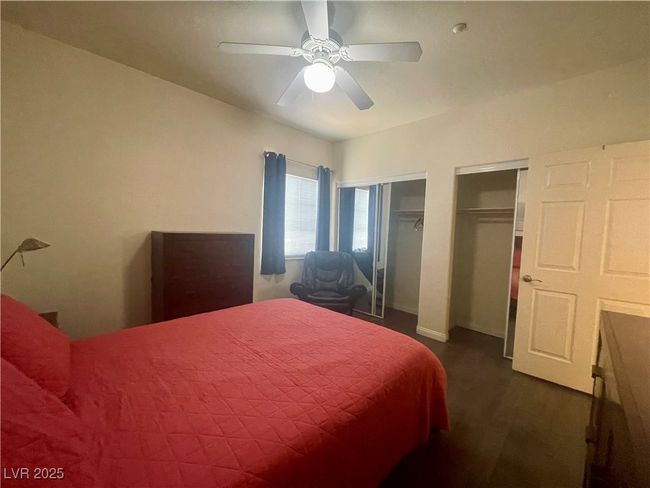 Bedroom featuring dark wood-type flooring, multiple closets, and a ceiling fan | Image 39
