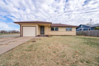 Ranch-style home featuring a garage and a front lawn | Image 1