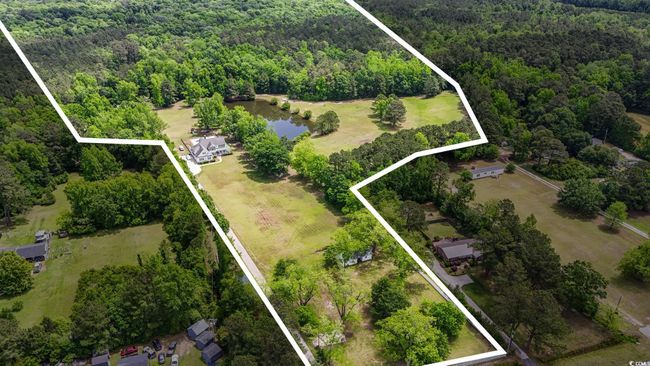 Aerial overview of property's location with a forest, property parcel outlined, and a large body of water | Image 40