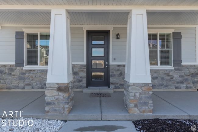 Doorway to property with a porch and stone siding | Image 4