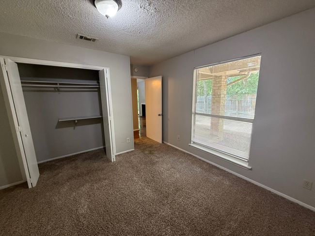 Unfurnished bedroom featuring a closet, carpet floors, and a textured ceiling | Image 15
