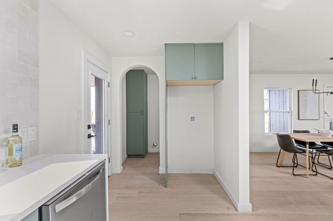 Kitchen with dishwasher, light wood-style flooring, light countertops, and arched walkways | Image 23