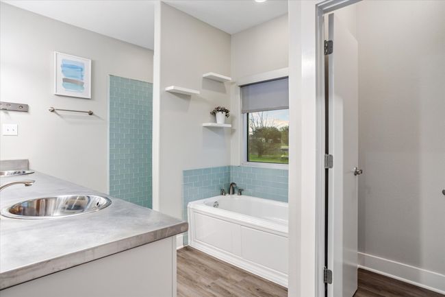 Bathroom with hardwood / wood-style flooring, vanity, and a bathtub | Image 13