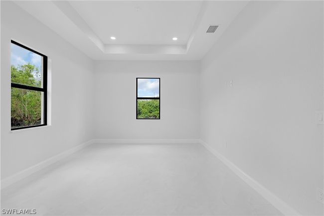 Spare room featuring plenty of natural light and a tray ceiling | Image 39