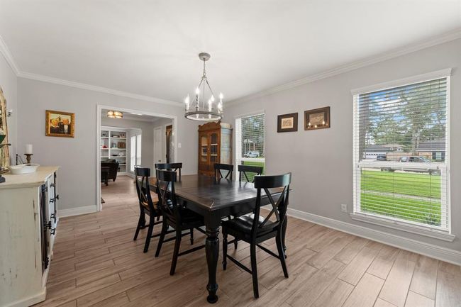 This dining room features large windows letting in natural light. | Image 14