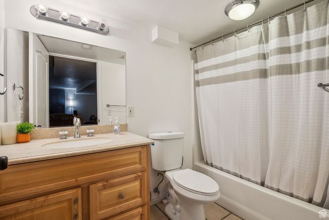 Full bath with toilet, shower / tub combo, tile patterned flooring, vanity, and connected bathroom | Image 40