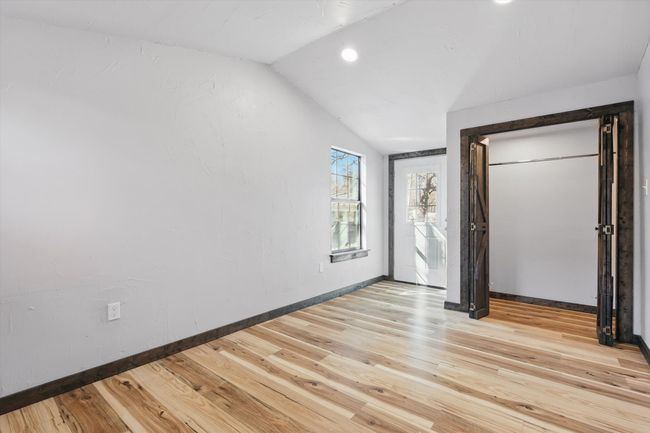 Unfurnished bedroom with light wood-type flooring, baseboards, and vaulted ceiling | Image 11