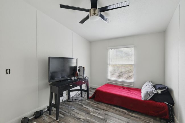 Bedroom with lofted ceiling, baseboards, a ceiling fan, and wood finished floors | Image 22