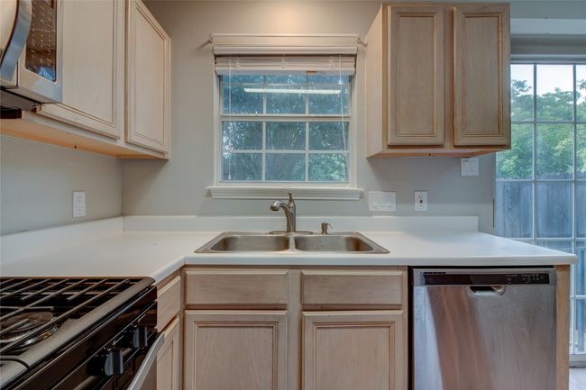 Kitchen with stainless steel appliances, light brown cabinetry, a sink, and light countertops | Image 18