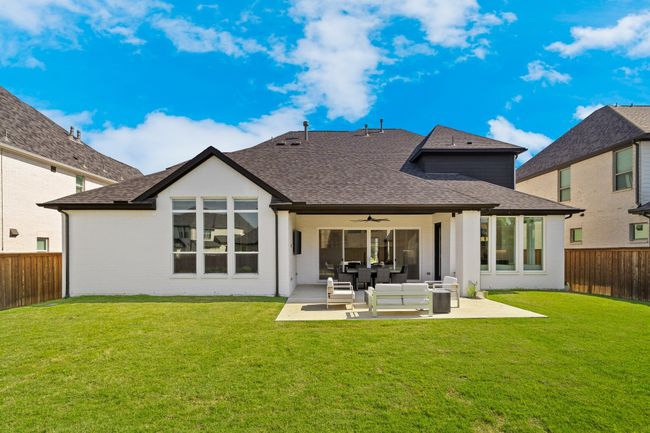 Rear view of property featuring roof with shingles, ceiling fan, a patio, and an outdoor living space | Image 37