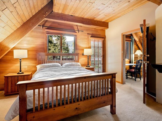 Bedroom with vaulted ceiling with beams, carpet, wooden ceiling, and wood walls | Image 20