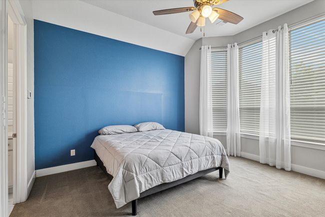 Bedroom featuring baseboards, ceiling fan, carpet, and lofted ceiling | Image 10