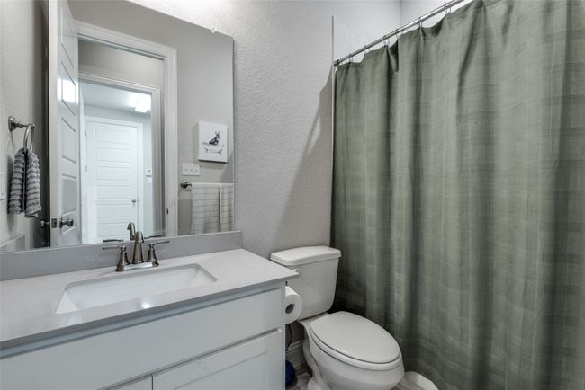 Bathroom featuring toilet, a textured wall, and vanity | Image 25